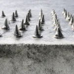 metal_spikes_lining_a_concrete_surface